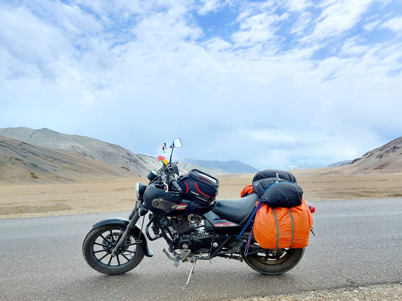 Mastering the First Impression: Your intriguing post title goes here Motorcycle parked in barren desert landscape near Pang under a blue sky.