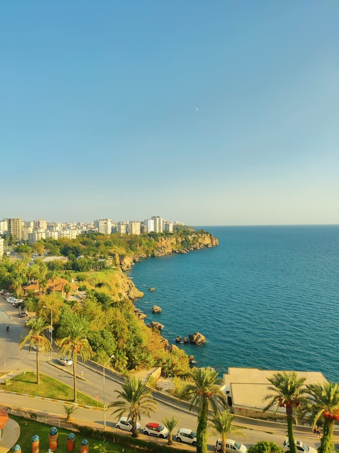 Explore the stunning aerial view of Antalya's coastline with vibrant cityscape and serene blue waters.